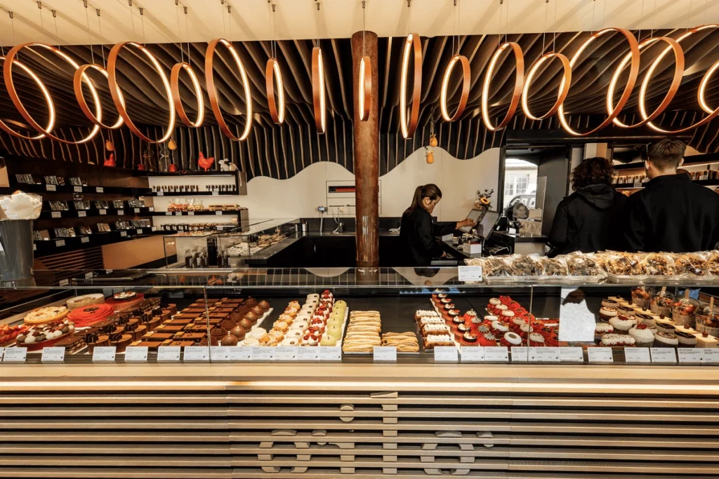 Pâtisserie sur présentoir avec magasin et vendeuse dans le fond